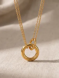 Makro-Detail einer goldfarbenen Edelstahlkette mit zwei ineinandergreifenden Ringen