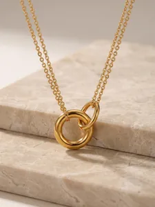 Nahaufnahme einer goldenen Edelstahlhalskette mit ineinander verschlungenen Ringen.