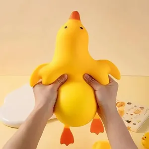 Close-up detail of hands squeezing an extra-large yellow duck slow rebound stress toy
