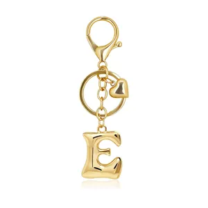 Detailed view of a golden bubble letter E keychain with heart charm and lobster clasp