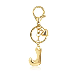 Close-up of a polished gold bubble letter J keychain with heart charm and lobster clasp