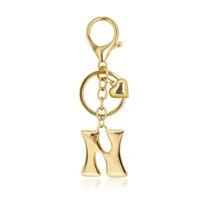 Detail of a polished gold bubble letter H keychain featuring a small heart charm and clasp