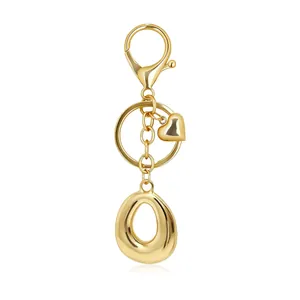 Detailed macro shot of golden letter O alphabet keychain featuring heart charm and lobster clasp