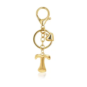 Close-up of polished gold letter T keychain with small heart charm and lobster clasp
