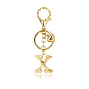 Detailed view of a shiny golden bubble letter X keychain with heart charm and lobster clasp