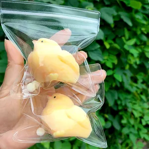 Detailed view of two fuzzy yellow chick squishy toys in clear zip bags for stress relief