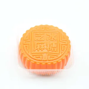 Detailed top view of a realistic orange mooncake squeeze toy in plastic tray