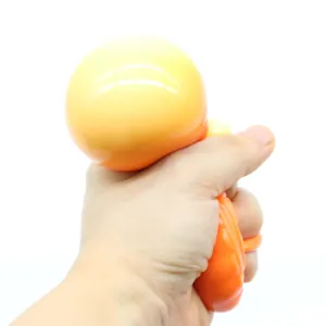 Detail view showing a hand squeezing an orange mooncake-shaped TPR stress relief toy