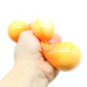 Detailed shot of an orange mooncake squeeze toy being compressed for stress relief