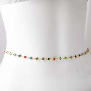 Close-up of gold-plated waist chain featuring multi-colored heart glass charms on a torso.