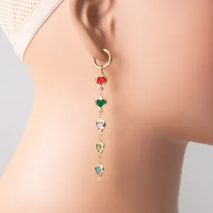Detailed view of long dangling earrings with multi-colored heart-shaped glass stones.