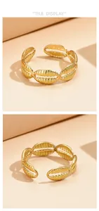 Vues détaillées d'une bague ouverte en acier doré avec motif coquillage sous deux angles
