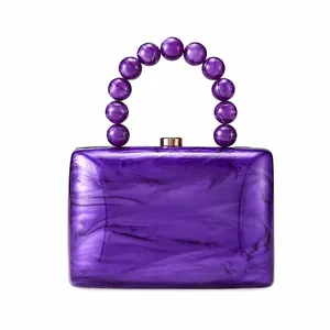 Vue détaillée d'une pochette de soirée en acrylique violet avec poignée en perles