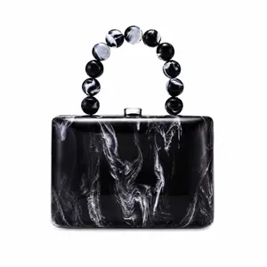 Sac de soirée élégant en acrylique marbré noir et blanc avec une poignée perlée unique