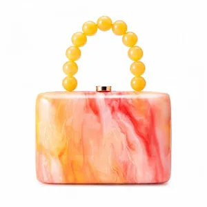 Pochette de soirée en acrylique marbré orange-rose avec poignée en perles jaunes