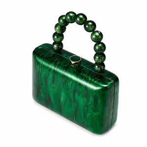 Vue détaillée du sac de soirée en acrylique marbré vert émeraude avec sa poignée perlée chic
