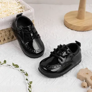 Detailansicht schwarzer Lackleder-Babyschuhe mit rutschfester weicher Sohle und Schnürung.