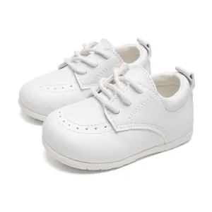 Detailansicht weißer Kunstleder-Babyschuhe mit klassischem Lochmuster im Brogue-Stil