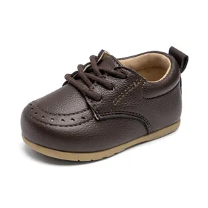Nahaufnahme brauner Baby-Lauflernschuh aus Leder mit Budapester-Muster und weicher Sohle