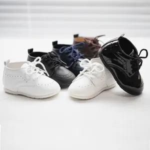 Nahaufnahme von mehrfarbigen weichen Baby-Lederschuhen mit feinen Brogue-Verzierungen.