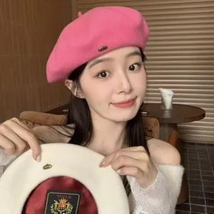 Detailed view of women's vintage wool beret hat featuring red silk lining and shield logo.