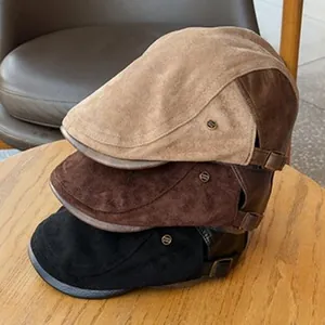 Detail view of vintage wool berets in khaki, brown, and black stacked on a wooden table.