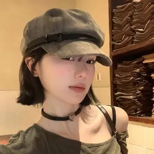 Stylish gray vintage wool newsboy cap worn by a model in a cozy indoor setting