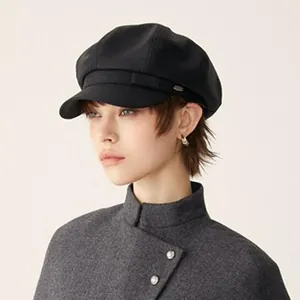 Elegant black British style wool baker boy hat worn by a female model in winter coat