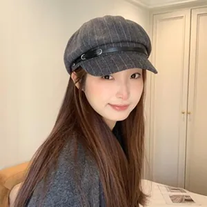 Asian female model wearing a grey pinstripe wool newsboy cap with leather strap detail