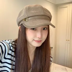 Close-up of a stylish woman wearing a chic British vintage wool newsboy hat in khaki color