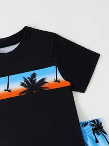 Close-up detail of boy's black swimwear top with tropical palm tree sunset print