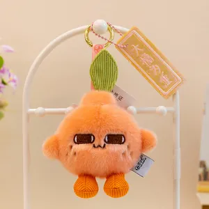 Primer plano de un lindo llavero de peluche de naranja con una etiqueta de buena suerte