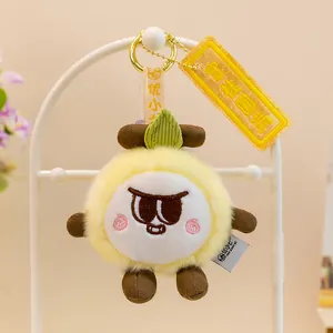 Primer plano de un llavero de peluche de fruta amarilla con una hoja y cara bordada