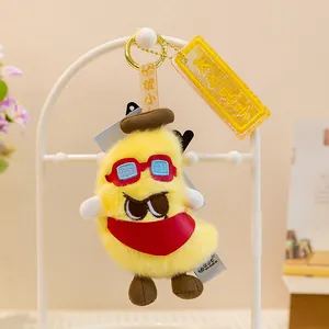 Primer plano detallado de un lindo llavero de plátano de peluche amarillo con bufanda roja