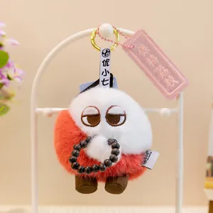 Detalle de un lindo colgante de muñeco de peluche rojo y blanco con una pulsera