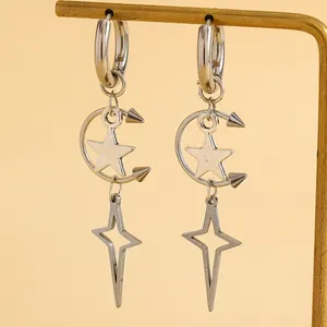 Gros plan de boucles d'oreilles punk argentées étoile et lune sur un support doré