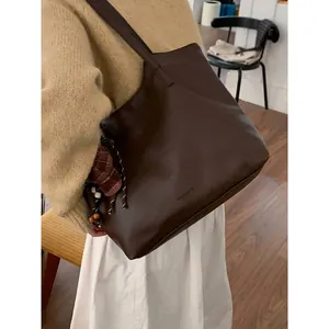 Vintage large capacity brown faux leather tote bag worn by model in a casual setting