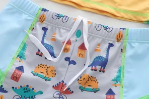 Detalle de bañador infantil con estampado de dinosaurios y cordón blanco ajustable