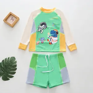 Primer plano detallado de los estampados de astronauta y dinosaurio en el traje de niño.