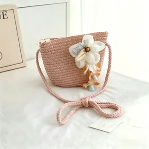 Pink woven straw crossbody bag detail view with elegant white flower and beads