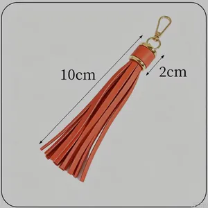 Macro detail of a 10cm orange leather tassel keychain showing precise measurements.