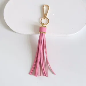 Detailed view of a 10cm pink leather tassel keychain with golden lobster clasp.