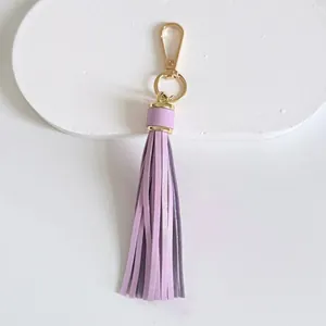 Detailed view of a light purple leather tassel keychain with gold-plated metal clasp