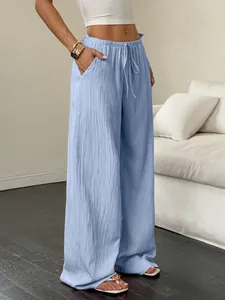 Detail view of light blue wide-leg casual pants with textured fabric and drawstring waist