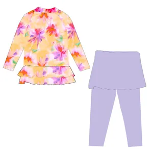 Costume da bagno due pezzi da ragazza con rash guard floreale e leggings con gonnellino.