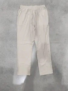 Vista detallada de pantalones de lino beige para hombre con corte recto en fondo gris