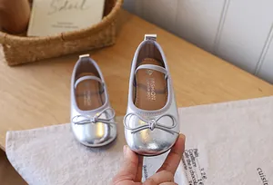 Detailed view of shiny silver girls princess ballet flats featuring a cute bow accent