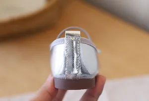 Detailed close-up view of silver metallic girl's princess shoe heel with neat stitching.