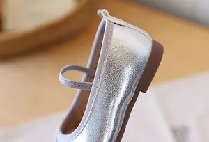 Detailed view of shiny silver metallic girls' princess shoes with elastic strap.