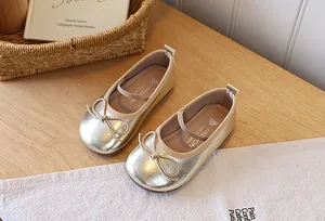 Detailed view of metallic gold girl's princess shoes with cute bow and elastic strap